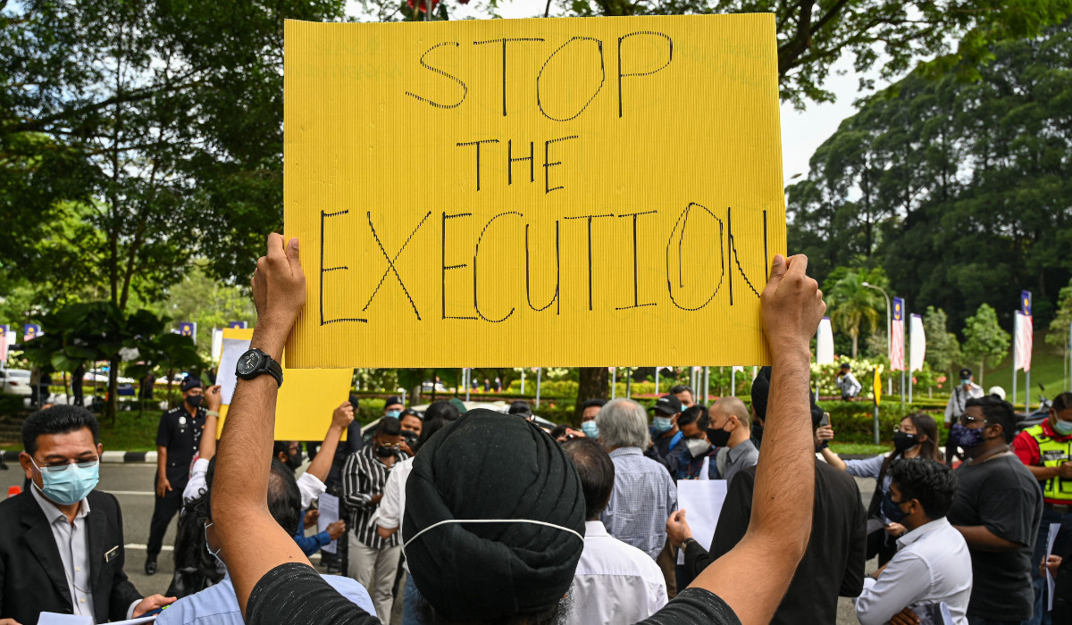 2021年11月3日，一名社運人士在吉隆坡高舉標語，隨後向國會提交報告，抗議Nagaenthran K. Dharmalingam因偷渡海洛因進入新加坡而被判死刑。他目前正在等待執行。(Photo by Mohd RASFAN / AFP)