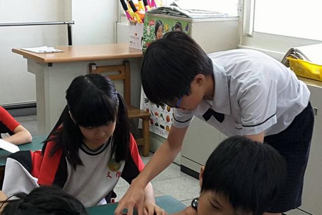2016年寫信馬拉松，嘉義文雅國小的高年級同學到學弟妹的教室，講解全球人權受侵害者的故事，並且指導學弟妹如何寫明信片聲援對方。© Amnesty International Taiwan