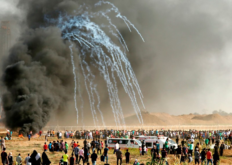 巴勒斯坦示威者在以色軍隊發射催淚彈後趕緊逃離並尋找掩護。©AFP via Getty Images