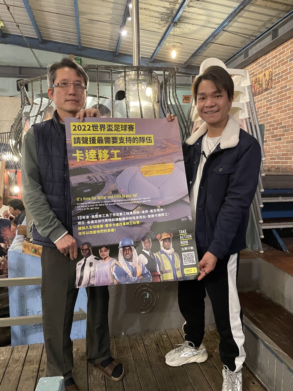 《九槍》導演蔡崇隆與越南移工朋友和國際特赦組織的卡達移工倡議海報合照。  