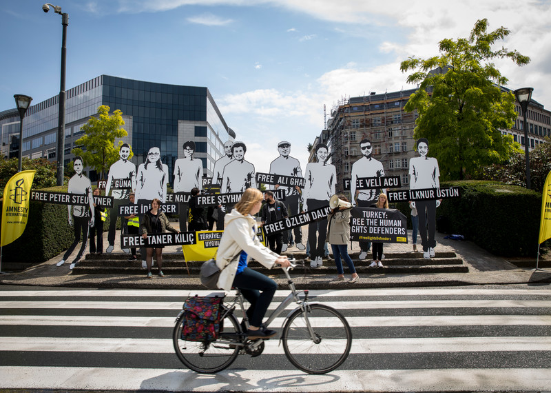 社運人士在位於布魯塞爾的歐盟委員會大樓外抗議，急迫要求公眾關注被監禁的人權捍衛者，其中包括國際特赦組織土耳其分會秘書長艾德爾・伊瑟（İdil Eser）和理事會主席泰納・齊李克（Taner Kılıç）。© Amnesty International