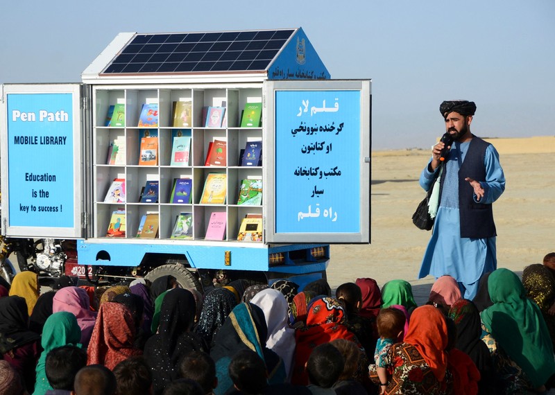 「筆徑」PenPath負責人、阿富汗女童受教權倡議人士馬蒂烏拉・韋薩（Matiullah Wesa）在坎達哈省（Kandahar）史賓波達克區（Spin Boldak）移動圖書館旁的課堂上向孩子們講話。韋薩是一項阿富汗女童教育計畫的創始人，他因為這樣的工作而在喀布爾被塔利班當局拘留。© AFP via Getty Images